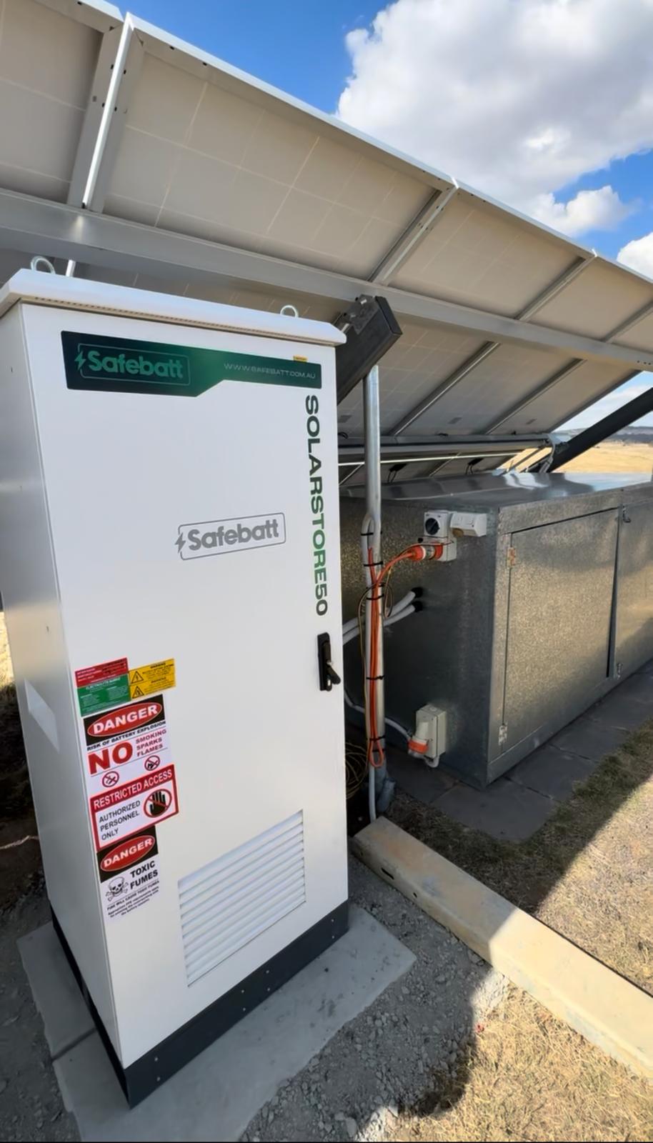 SolarStore50 battery cabinet under a ground-mount solar array