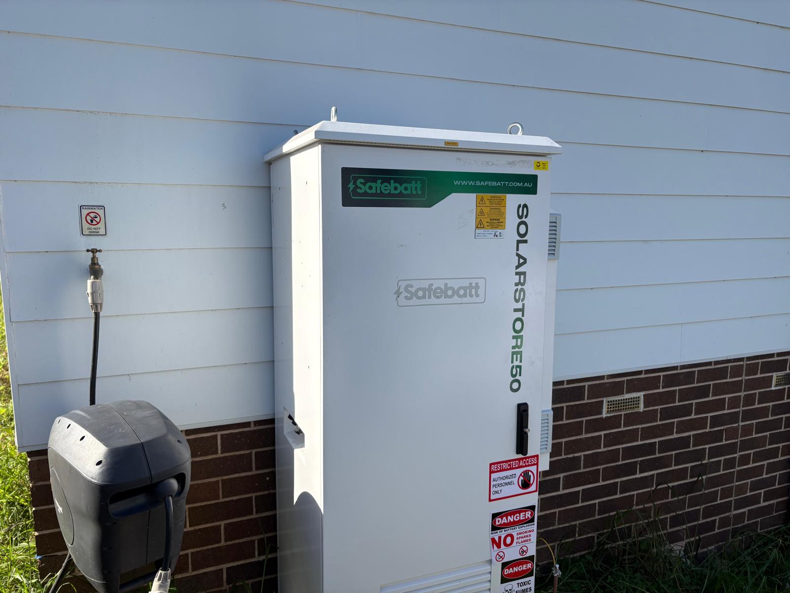 SolarStore50 battery installed against a weatherboard farmhouse